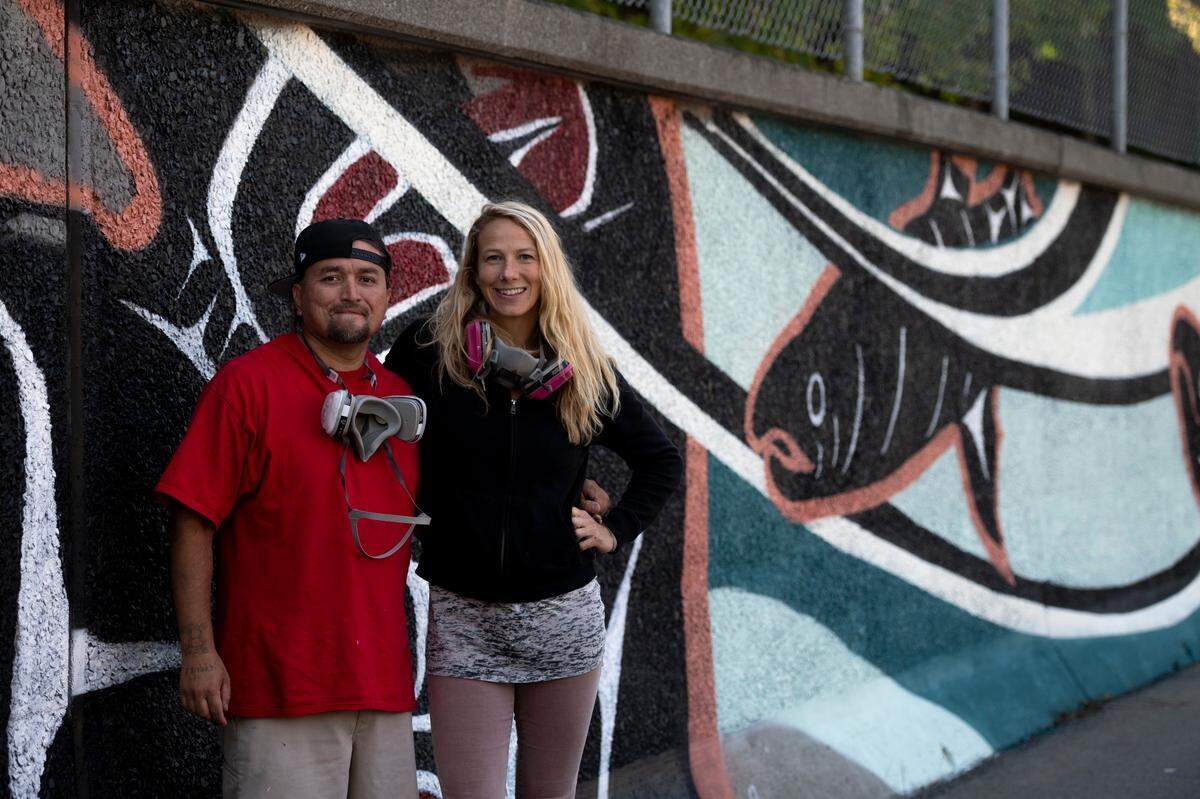 Jason LaClair and Gretchen Leggitt pose in front of a new mural they painted together on Forest Street on Thursday, Sept. 2, in Bellingham.