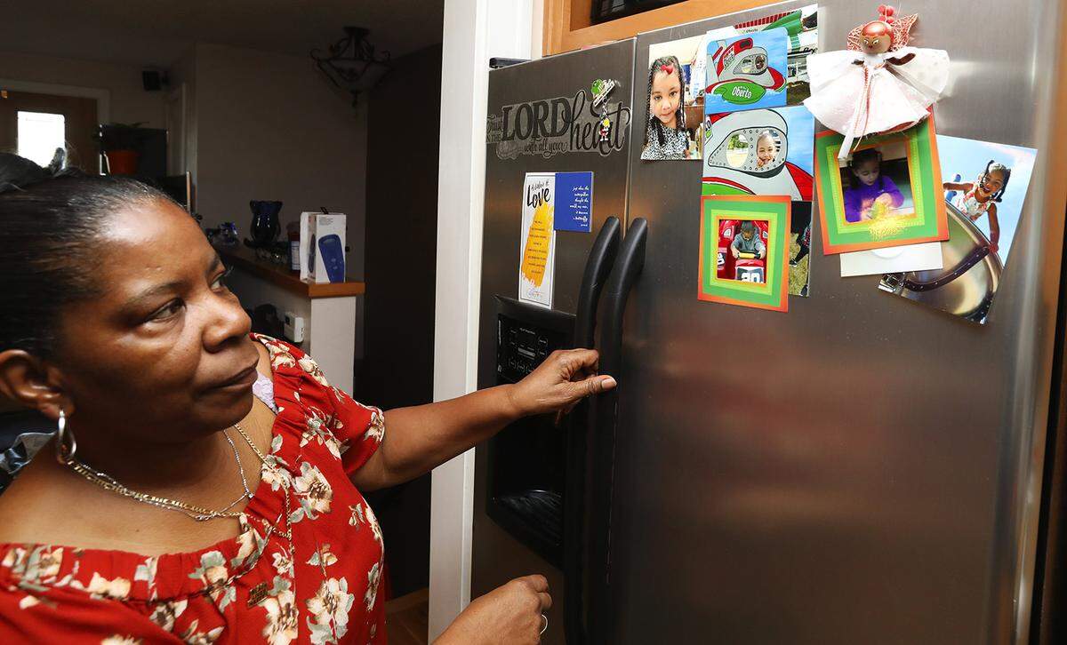 Alesia Cannady looks at photos of her granddaughter Aleiyah Cannady while preparing the 4-year-old breakfast before taking her to preschool in September 2018 in Seattle. Alesia, 64, has raised Aleiyah almost from birth and doesn’t get benefits afforded to foster parents.