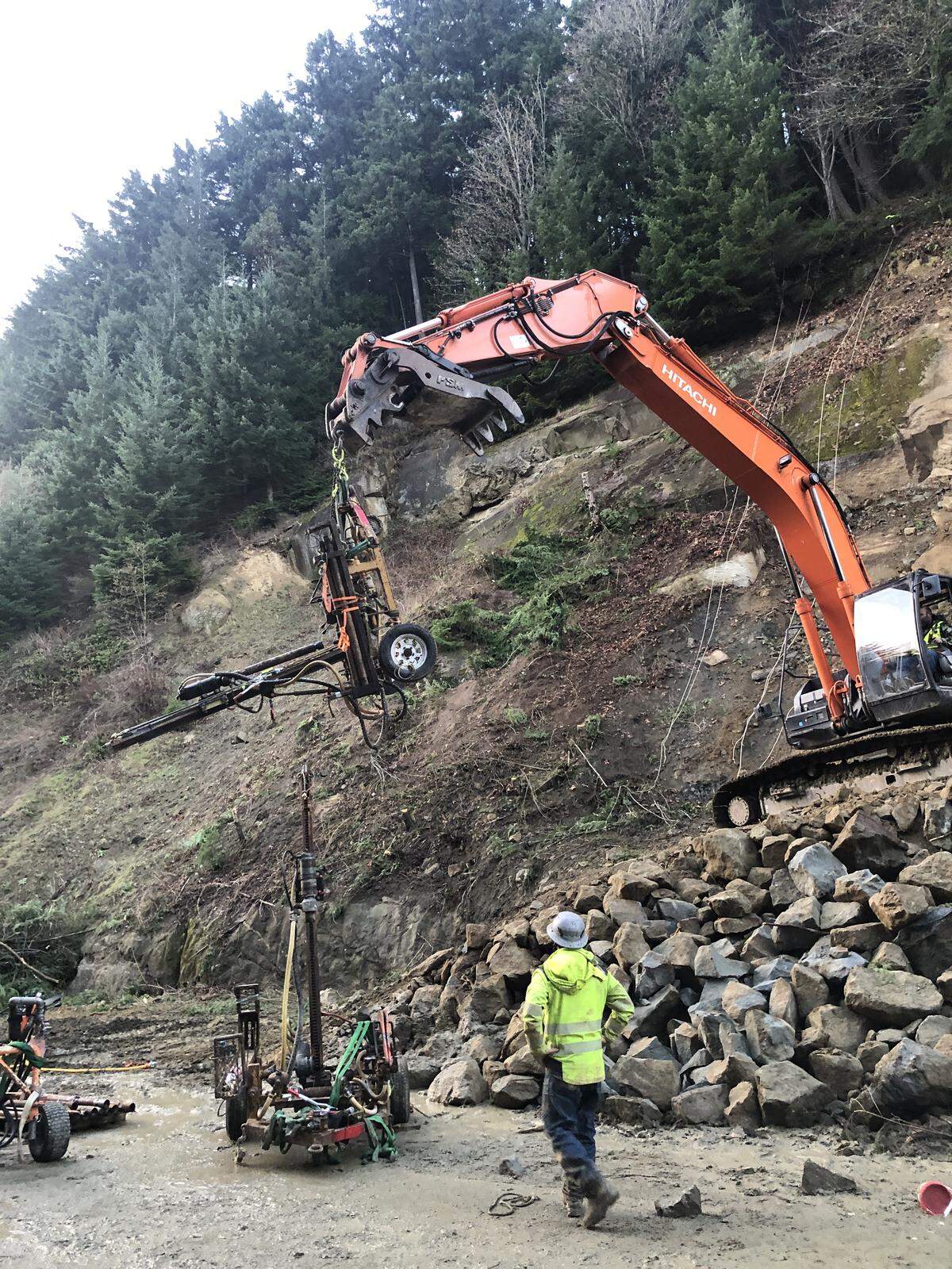 Scaling back the slope is no longer the focus of the Interstate 5 landslide cleanup, as drilling holes for steel dowels is now the priority.
