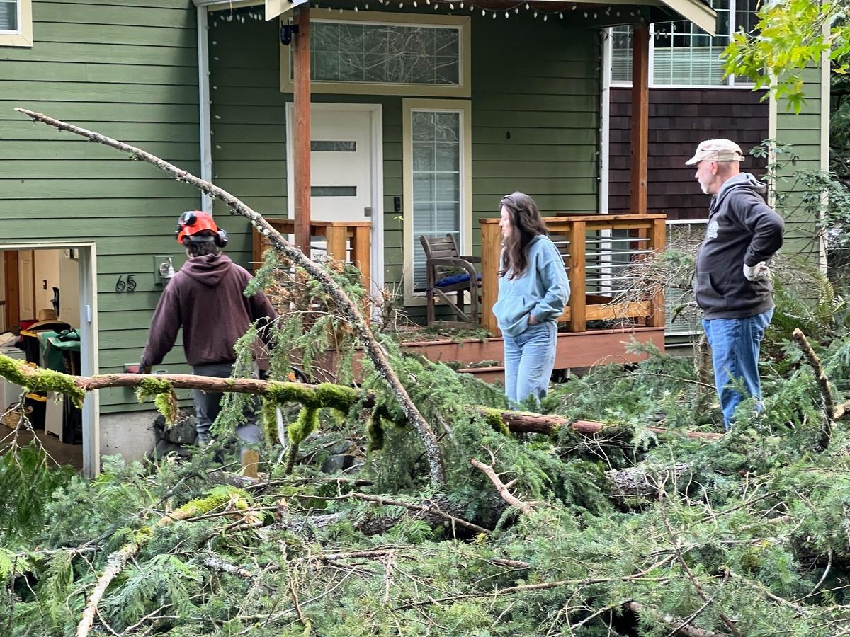 Lucas Shield, left, his mother Malia Shield and neighbor Bill Wendt, right, examine damage from a powerful windstorm on Wednesday, Nov, 20, 2024, in Sudden Valley east of Bellingham, Wash.