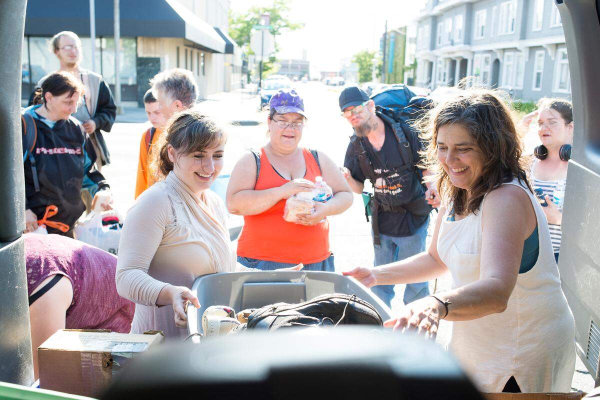 Street Connect volunteers Nadia Ng, left, and Diane Reardanz grab a box of shoes from the back of the Street Connect van in Bellingham.