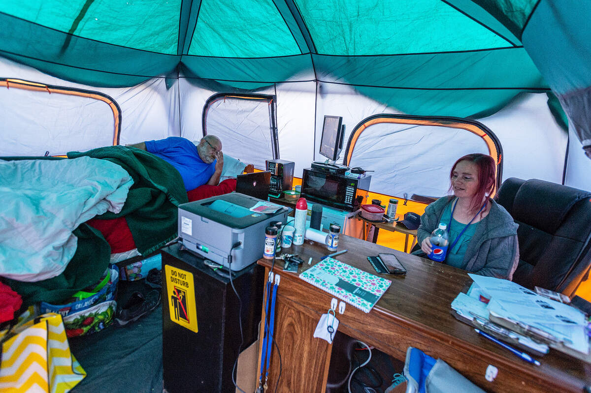 Jim Peterson, president of HomesNOW! readies for bed as Rachel Duval closes the office for the day at the Safe Haven homeless encampment.. The city of Bellingham requires that someone from the nonprofit organization be there at all times. Duval, one of the first residents at the encampment, is now vice president of HomesNOW! She is no longer homeless.
