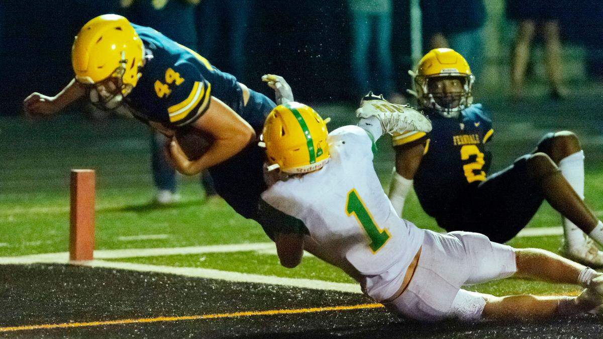 Ferndale wide receiver Damien Toney (2) watches team mate tight end Jordan Mason (44) dive for a touchdown as Lynden defensive back Kobe Baar (1) attempts to stop his progress Friday evening Sept. 2, at Blaine High School.