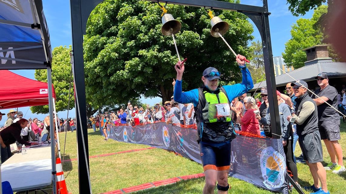 Jeff Hilburn of Birch Equipment gives a two-fisted ring of the bell as he reaches the finish line of the Ski to Sea relay race at Marine Park in Bellingham, Wash., securing a repeat win for the event’s 50th anniversary on Sunday, May 28, 2023.