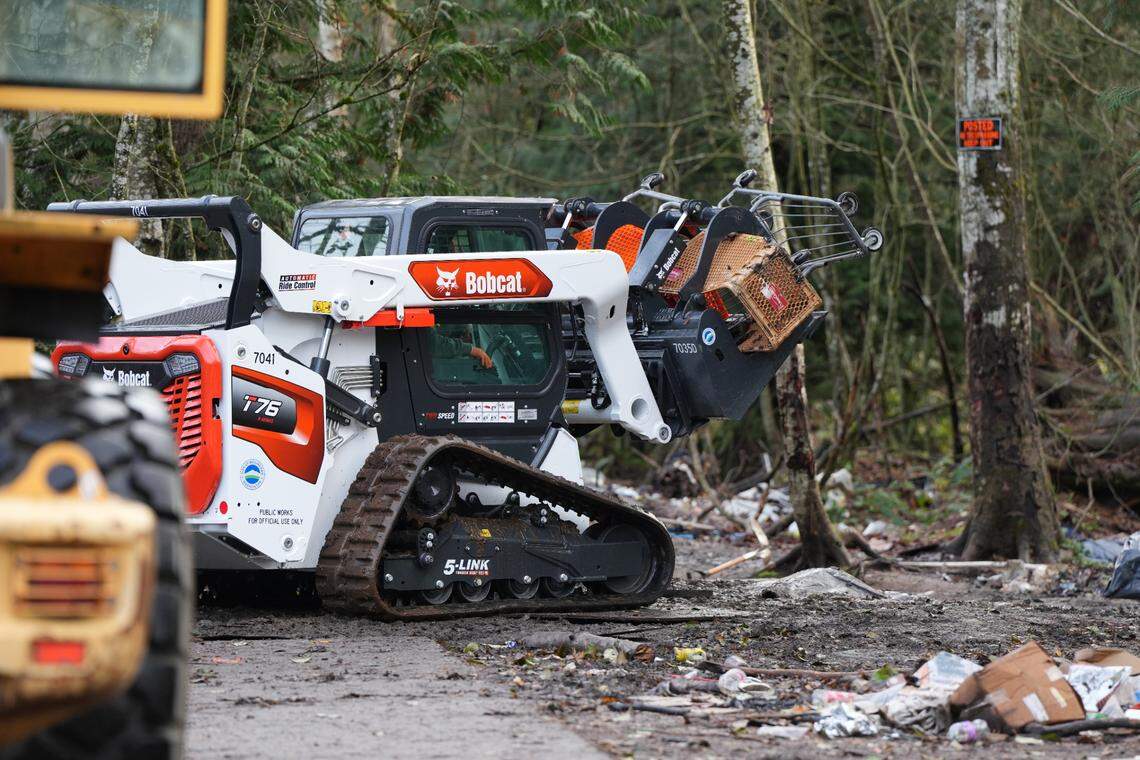 City crews used a Bobcat to clear shopping carts and other large items from the encampment behind Walmart.