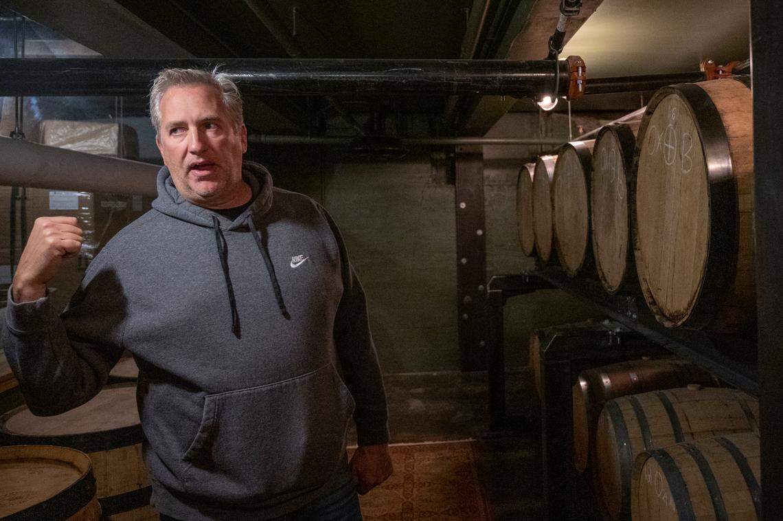 Kelly Andrews, co-owner of Chuckanut Bay Distillery, stands among barrels of whiskey and other distilled liquors on April 28 in Bellingham.
