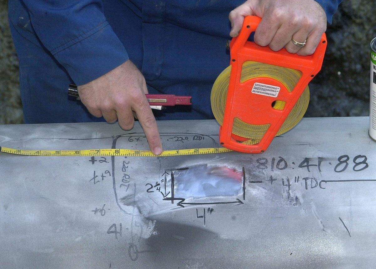 Measurements are taken in June 2000 of a small anomaly found in a section of 16-inch diameter pipeline that runs between Cherry Point and Renton. Agra Pipeline Professionals technicians said the small imperfection was most likely caused by a rock and poses no danger to the pipe’s integrity.
