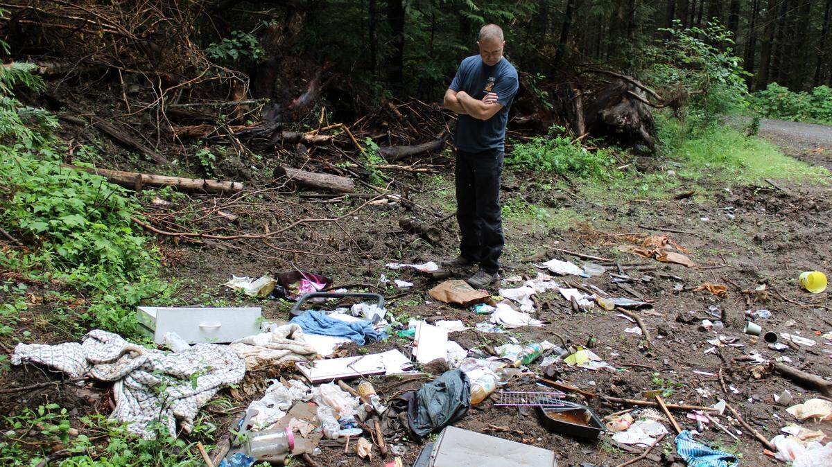 Cory McDonald, proprietary forester for the Washington Department of Natural Resources’ Northwest region, looks at trash left on Sumas Mountain in Deming during a tour Thursday, Aug. 4.
