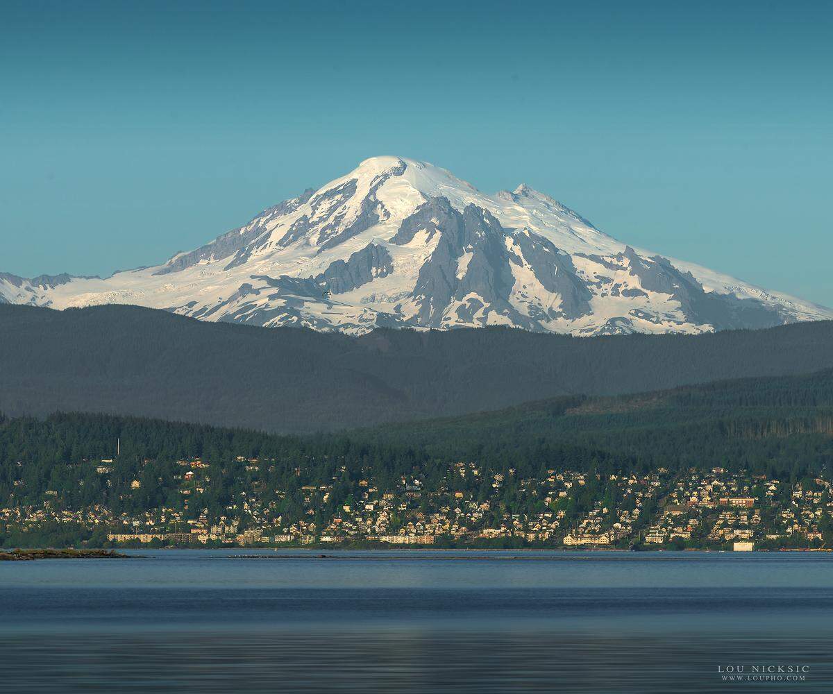 Mt. Baker rises behind the City of Bellingham in a view from Lummi Shore Road in July 2018. Whatcom County’s volcano has two seismographs to monitor earthquake activity, said Carolyn Driedger of the USGS Cascades Volcano Observatory in Vancouver, Wash. “We have a lot to be done in regard to increased monitoring,” Dreidger said.”It’s a long haul and we’re making a lot of progress.”