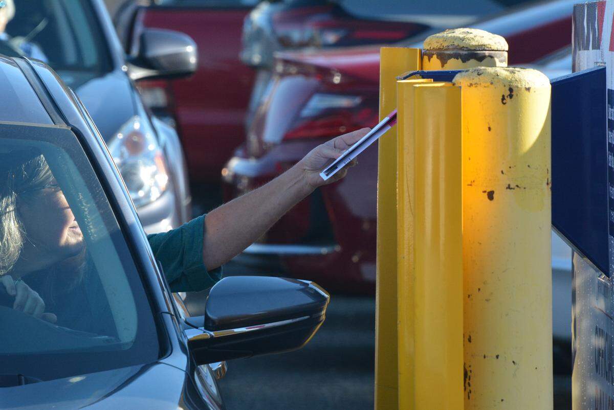 A voter places a ballot in a drive-up collection box outside the Whatcom County Courthouse in Bellingham on Tuesday.