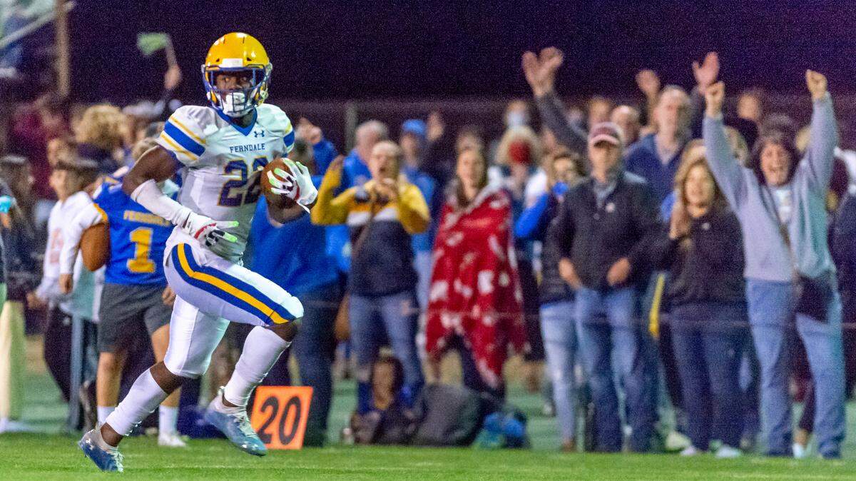 Supporters cheer as Ferndale running back Isaiah Carlson (22) breaks the line of scrimmage for an open field run to a touchdown Sept. 10, 2021, in Lynden. Carlson’s powerful fourth-quarter performance in a 27-24 comeback win over previously unbeaten Arlington kept the Golden Eagles tied at the top of the 3A Wesco North Saturday, Sept. 24.