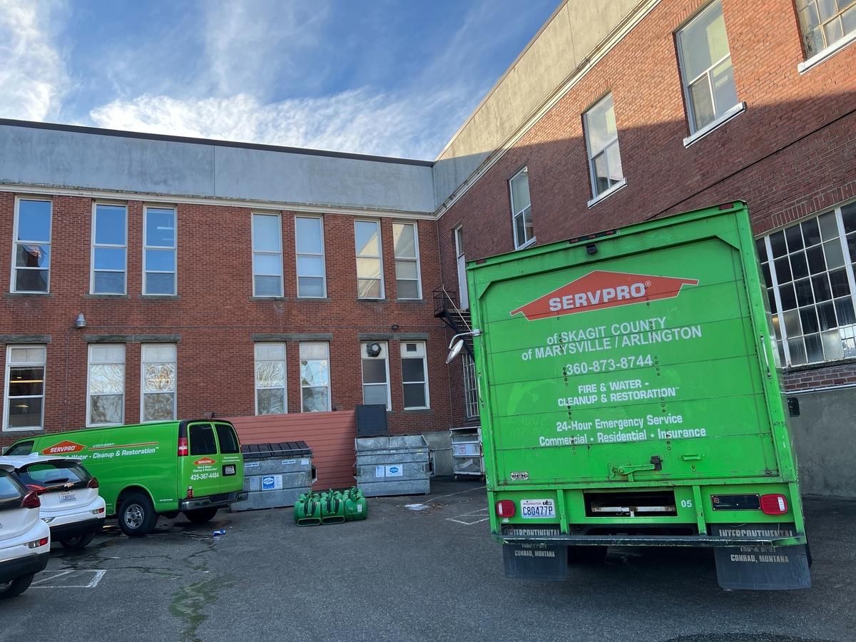 Trucks from a water damage restoration company are parked outside the Bellingham School District administrative offices on Saturday.