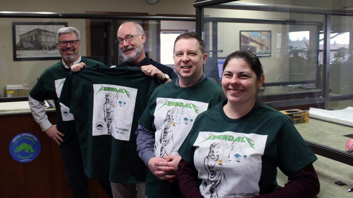 In an undated photo, Ferndale Community Development Director Michael Cerbone (left), Mayor Greg Hansen, Associate Planner Jesse Ashbaugh and Planning Coordinator Patti Gearhart (right) pose at the city’s permit desk with Metallica-themed shirts encouraging residents to build ADUs in Ferndale, Wash.