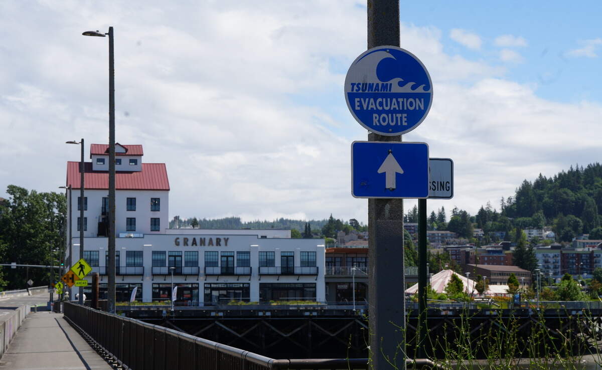 A sign directs people toward a tsunami evacuation route along the waterfront in Bellingham, Wash.
