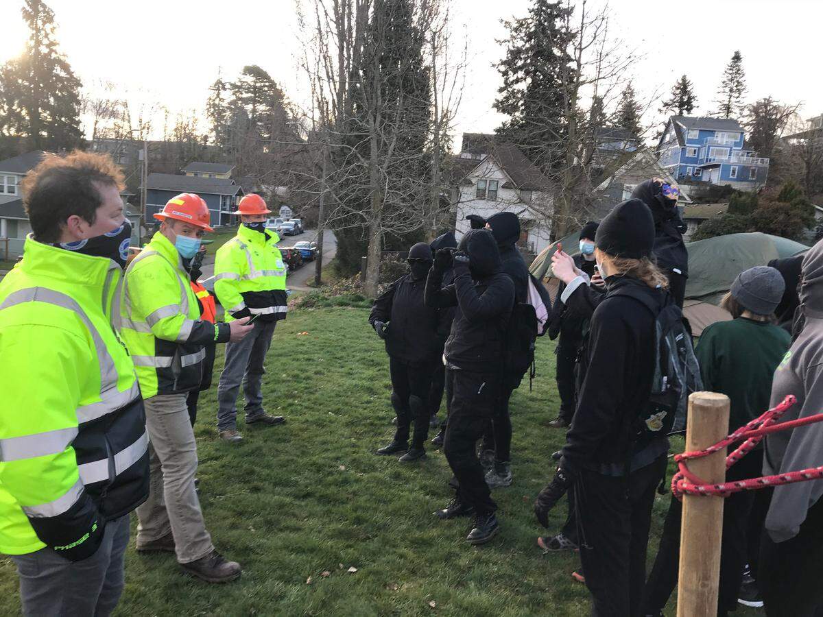 City parks workers face off with protesters angered that the city won’t allow homeless people to camp at Laurel Park in Bellingham, Friday, March 19.