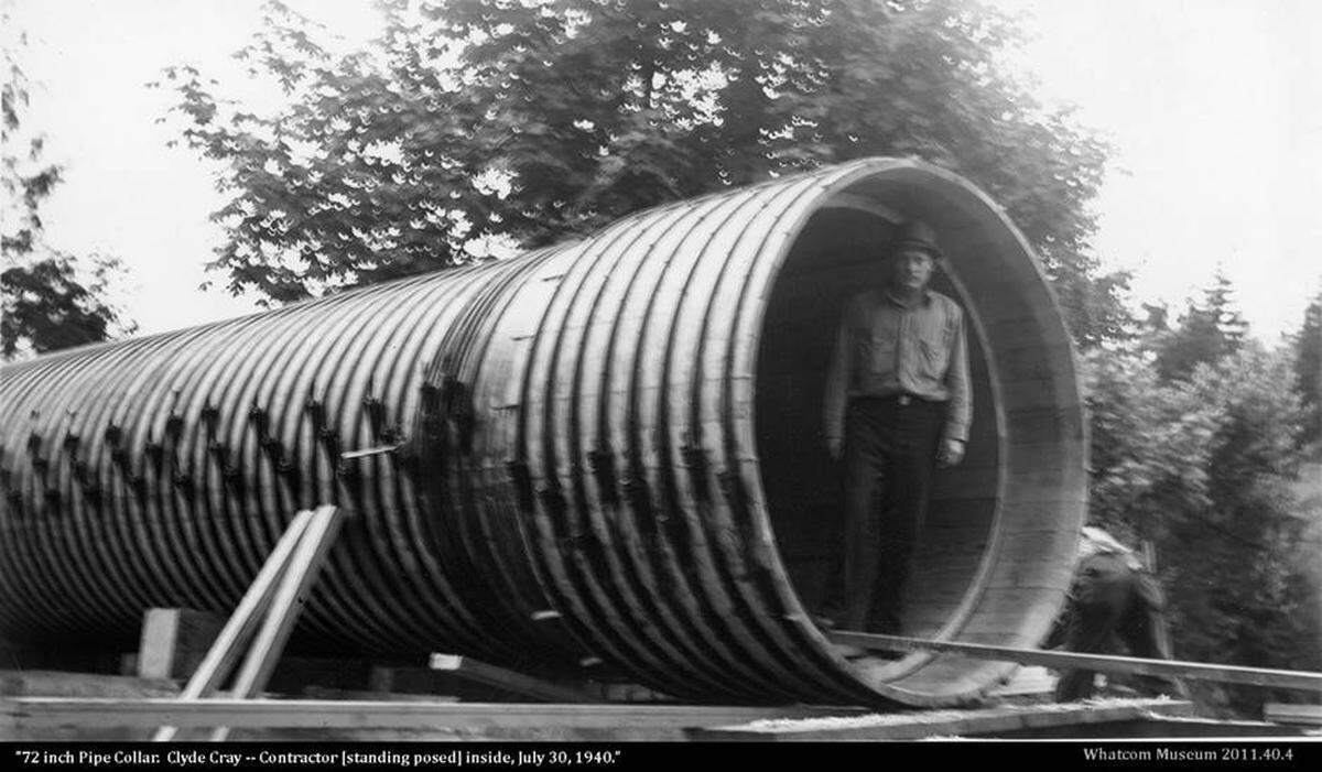 A photo now in the Whatcom Museum collection shows a contractor standing inside a red cedar pipe at Lake Whatcom in July 1940. A January 1941 Bellingham Herald article described its installation.