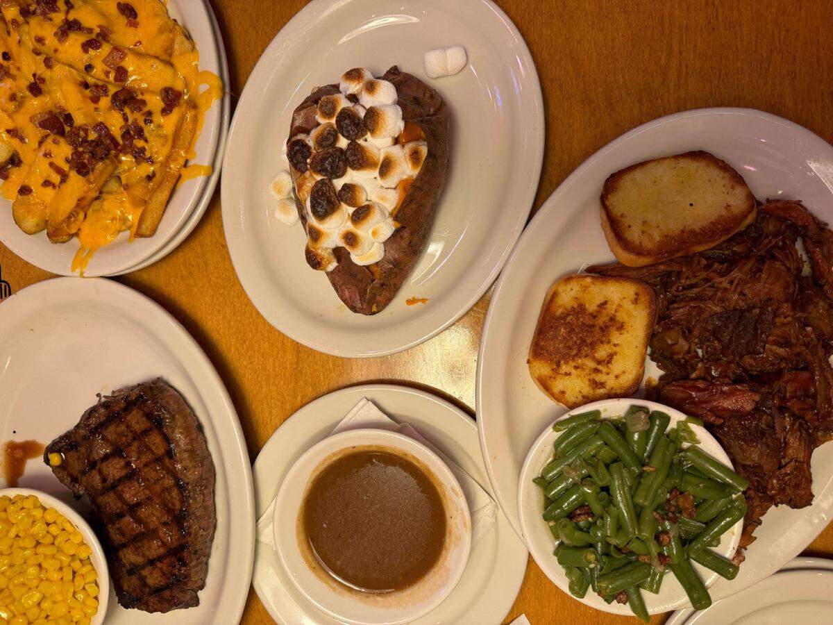 A sirloin steak, pulled pork dinner, baked sweet potato, loaded steak fries, green beans, sweet corn and gravy at Texas Roadhouse on Monday, October 7, 2024 at 4331 Meridian St., Bellingham, Wash.