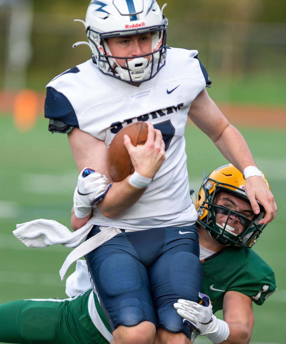 Sehome defensive back Max Malo (14) takes down Squalicum wide receiver Reed Richardson (7) after a short gain during the second quarter on Friday evening, Oct. 1, at Civic Stadium in Bellingham. Squalicum defeated Sehome 27 to 0.