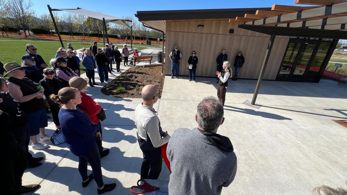 Bellingham Mayor Kim Lund, center, speaks to city workers and community members at a ribbon-cutting ceremony for “phase two” of Cordata Park on Friday. The expansion features a community center with a kitchen and restrooms that can be rented for meetings.