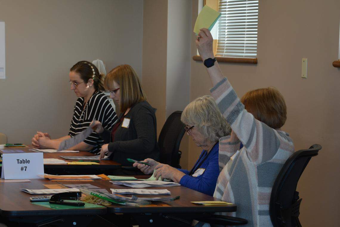 An elections worker signals to ask a question as the recount continued Monday at the County Courthouse. Only green markers were allowed at elections workers tables, to eliminate the possibility that a ballot could be changed.