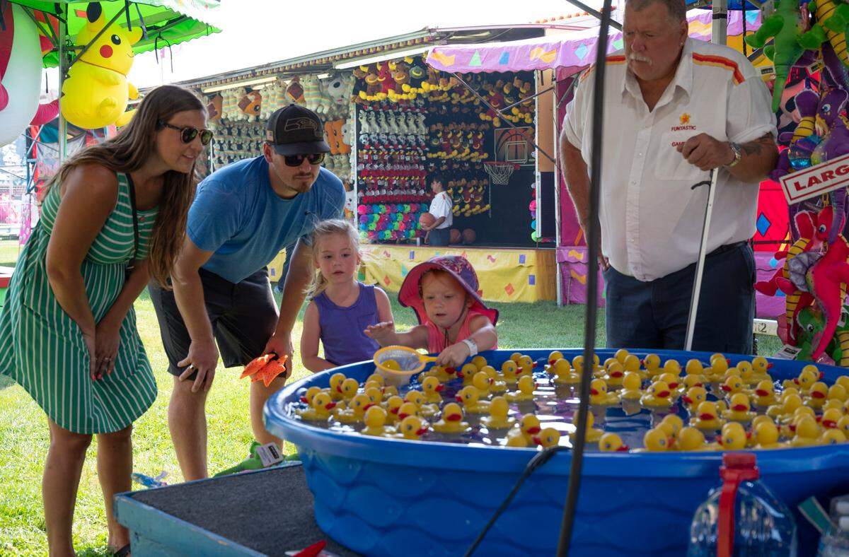 Leah Nicholes uses a net in her attempt to win a prize at the Northwest Washington Fair on Thursday, Aug. 12, in Lynden.