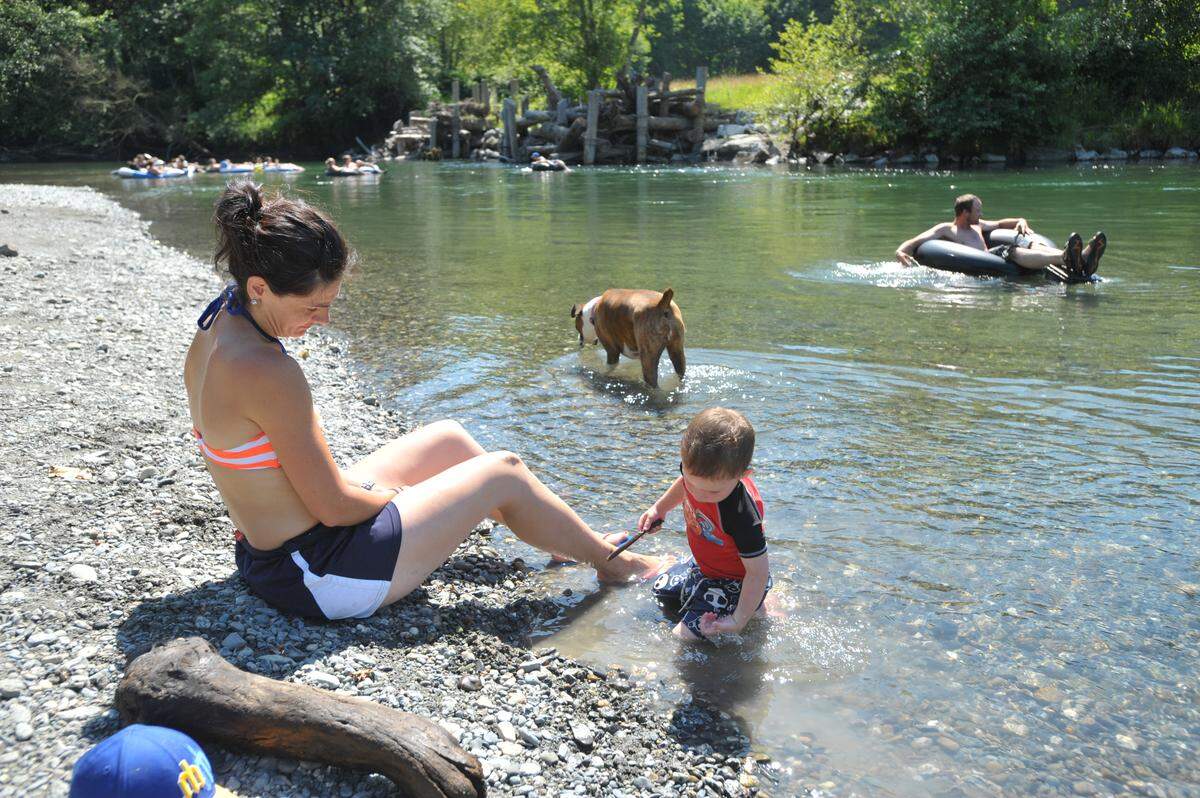 Lynne Wheeler watches her son Parker play at the river’s each as floaters head down the south fork of the Nooksack River between Acme and Van Zandt on Saturday, July 6, 2013 in Acme.”Our biggest issue isn’t that people come to the river, it’s the public safety issues. It’s the drunk driving, it’s the fighting,” says Wheeler.