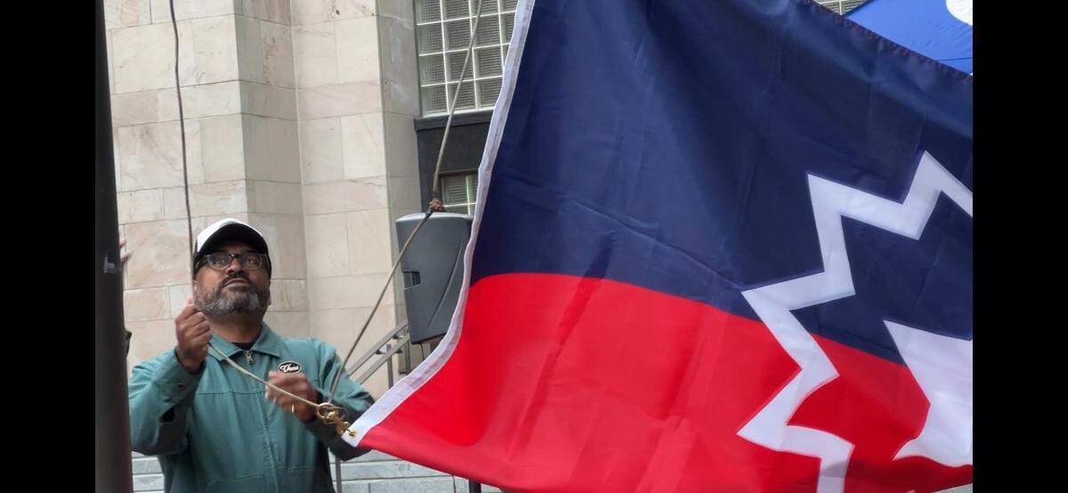 Jason McGill, head of Northwest Youth Services, hoists the Juneteenth flag in a ceremony on Monday, June 17, 2024, at City Hall in Bellingham, Wash.