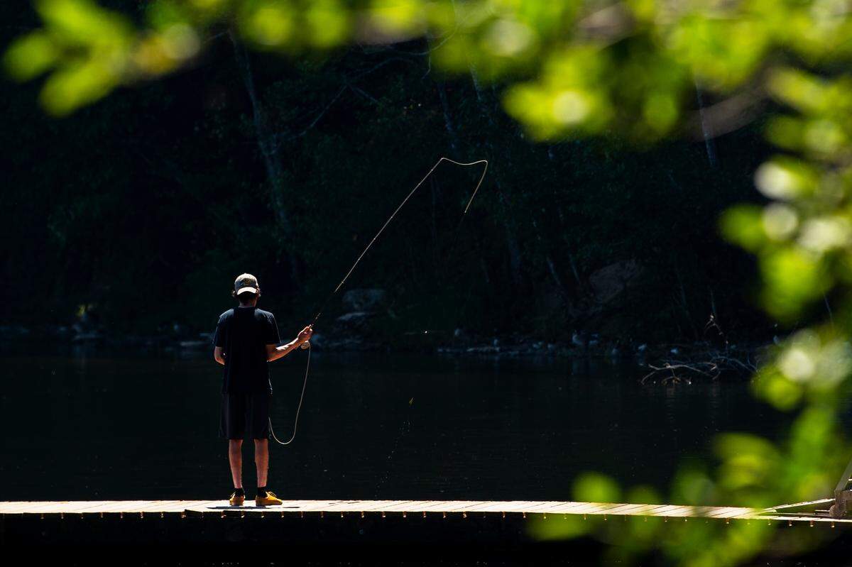 A fisherman casts his line into Lake Padden during record heat on Sunday afternoon June 27, in Bellingham.
