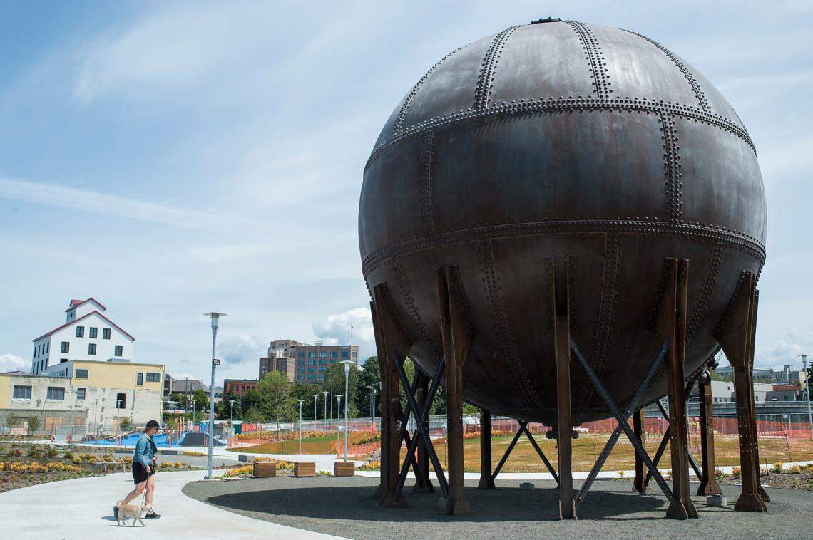 Allie Pasquier walks her dog Otto past the “acid ball” at Waypoint Park in Bellingham.