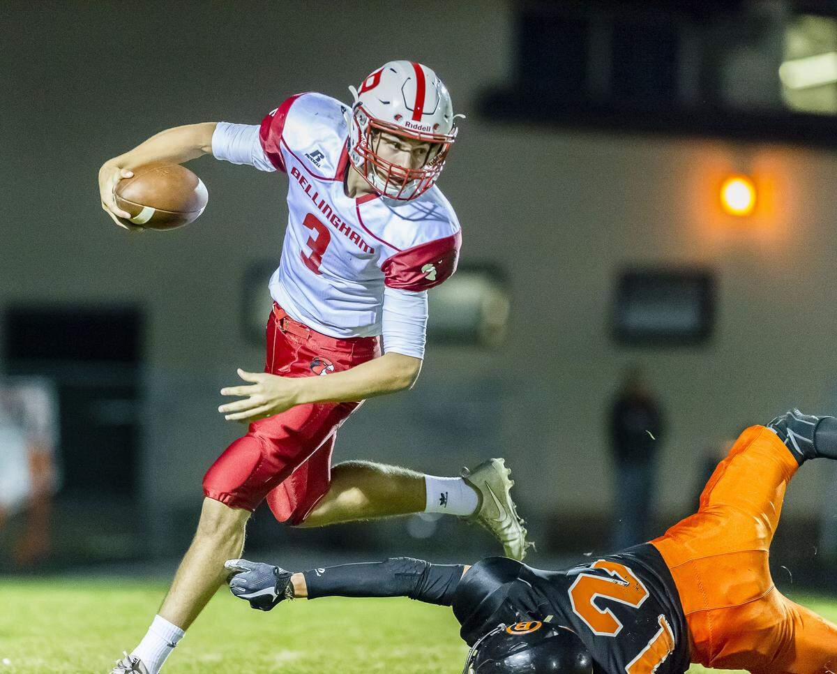 Bellingham quarterback Morgan Cavalier (3) evades a sack by Blaine defensiveman Ethan Deming (12) during the second quarter on Friday evening Sept. 28, 2018, at Blaine High School.