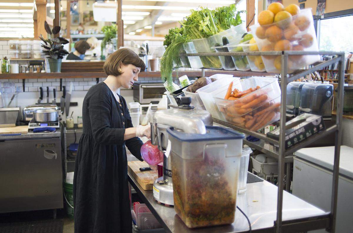 Ashton McNeely makes juice for a customer at Electric Beet Juice Co. at the Bellingham Public Market in August 2018. The business is moving into a new space at 1313 N. State St., near Saturna Capital.