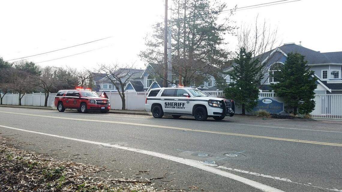 Public safety vehicles are parked outside the gates of the Chartwell Estates on the 900 block of Marine Drive west of Bellingham, Thursday, Dec. 26. A woman was shot and killed there Thursday morning and her alleged shooter was in custody, according to Whatcom County Sheriff Bill Elfo.
