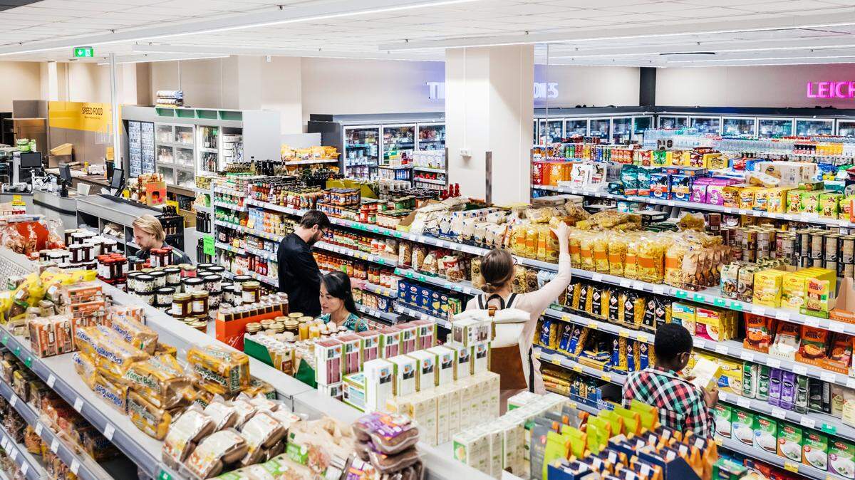 A busy and colorful supermarket with customers shopping for groceries.