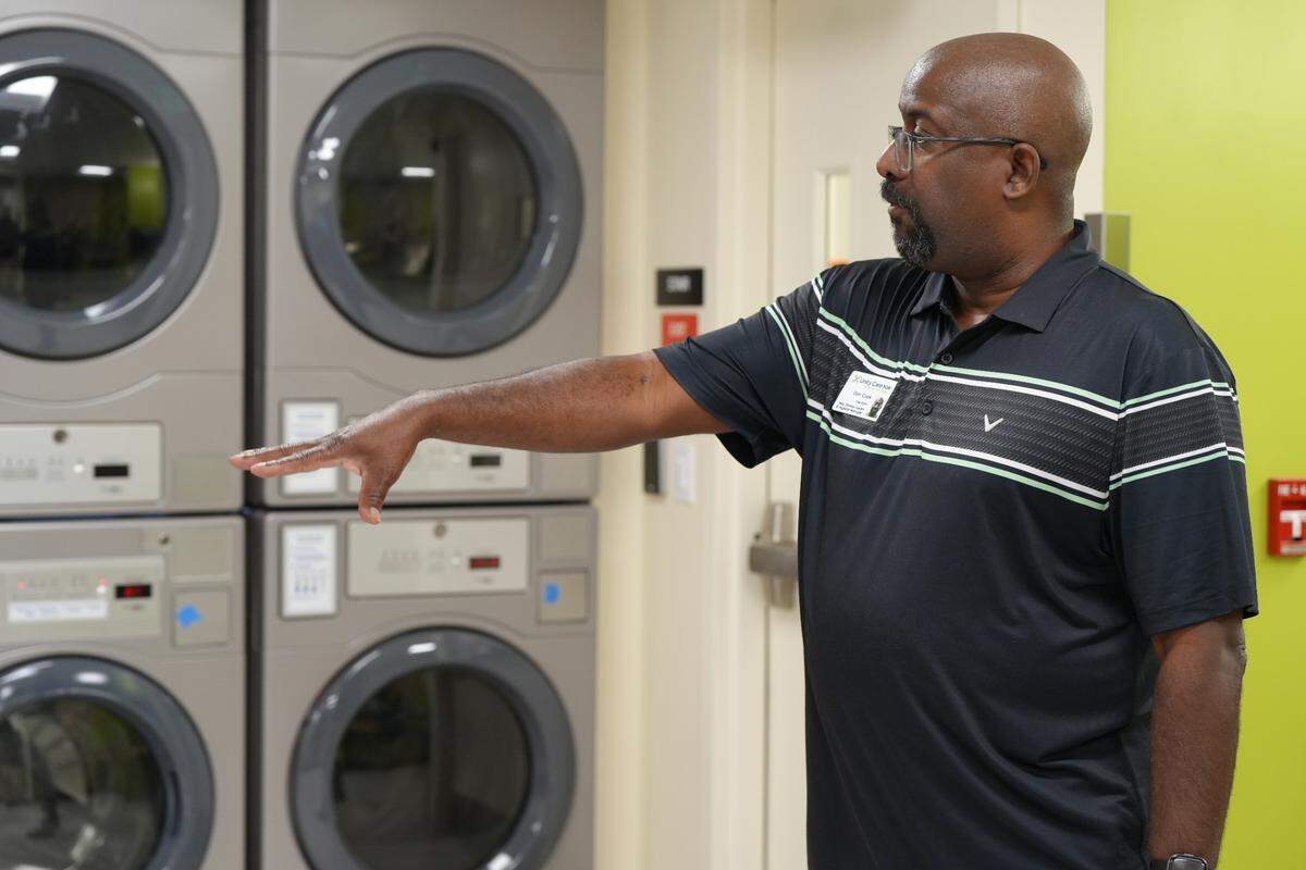 Don Cook leads a tour of the showers and laundry facilities at the Health and Hygiene Center in 2024.