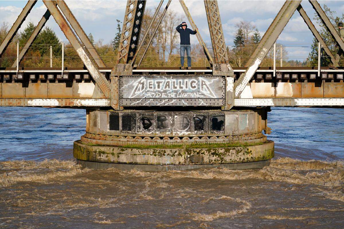 A pedestrian stands on Ferndale’s “Metallica Bridge” over the flooded Nooksack River in November 2021. 