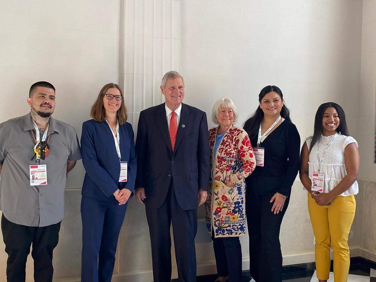 Steffan Kinley, left, is pictured with U.S. hackathon team lead Environmental Studies Professor Stacy Philpott, second from left, along with team members Crystal Salazar-Nieto, second from right, and Kennedy Bentley, right, meeting with U.S. Secretary of Agriculture Tom Vilsack and his wife, Christie Vilsack, at the G7 Ministers’ Meeting on Agriculture in Siracusa, Italy in September 2024.