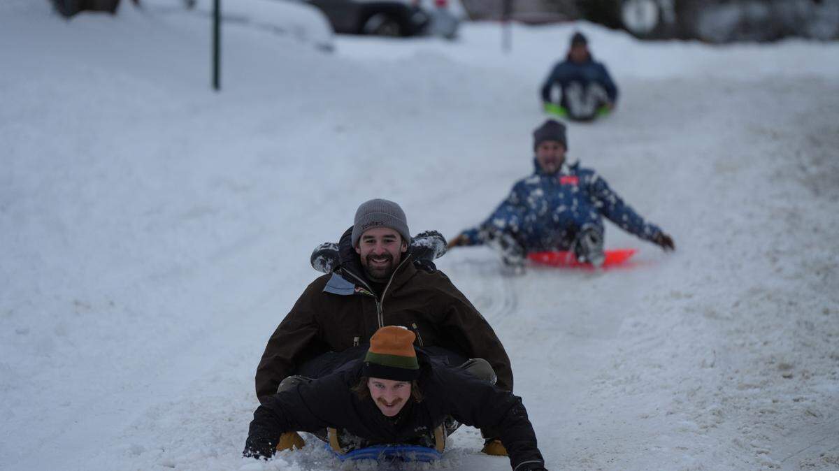 Mark Allison and North Bennett sled down E Pine Street on Wednesday, January 17, 2024, after the season’s first major snowfall of the year in Bellingham, Wash.