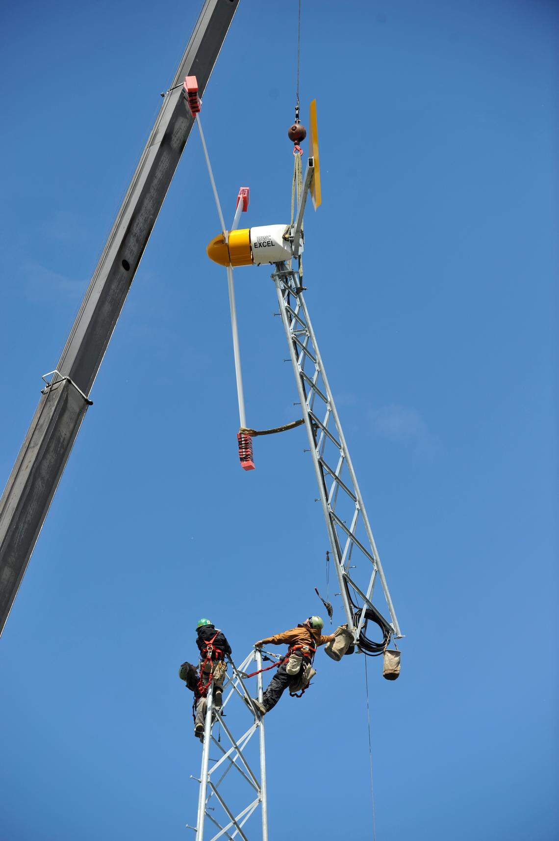 Technicians install top section of a 7.5kW wind turbine into place at Alpha Technologies, Inc, in Bellingham in 2010. The wind tower, solar array and generator showcase multiple renewable energy sources for remote communications systems.
