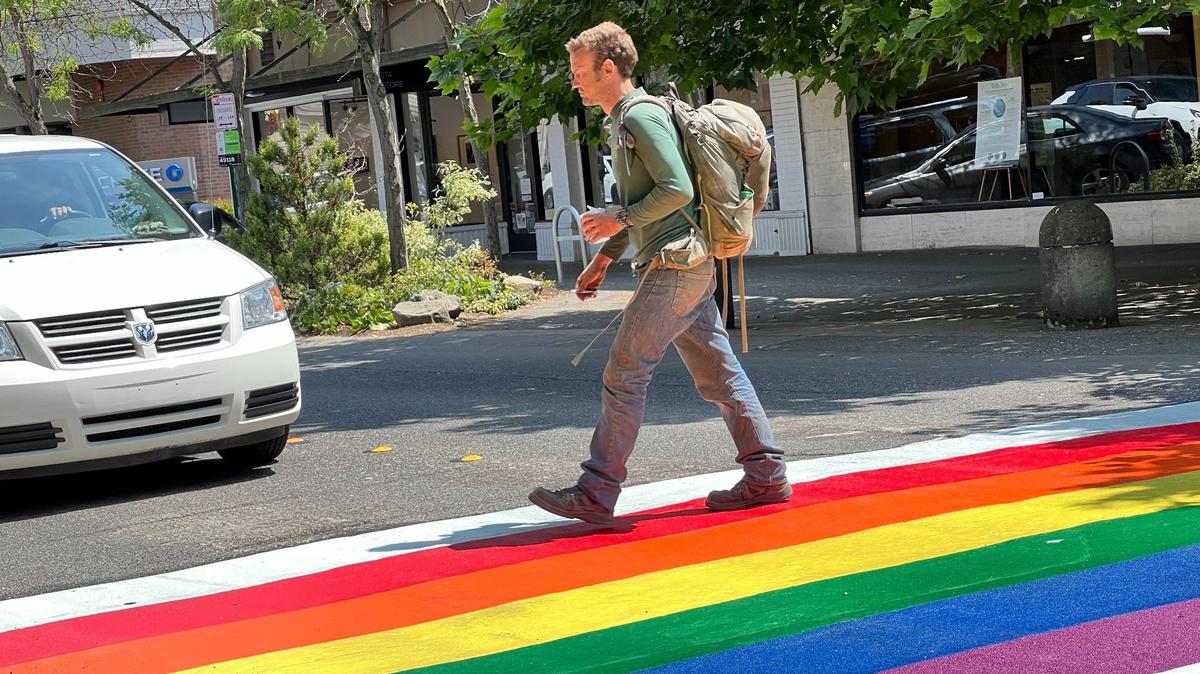 A driver waits for a pedestrian to cross Cornwall Avenue in the new Pride crosswalk between Holly and Magnolia streets on Friday in downtown Bellingham.