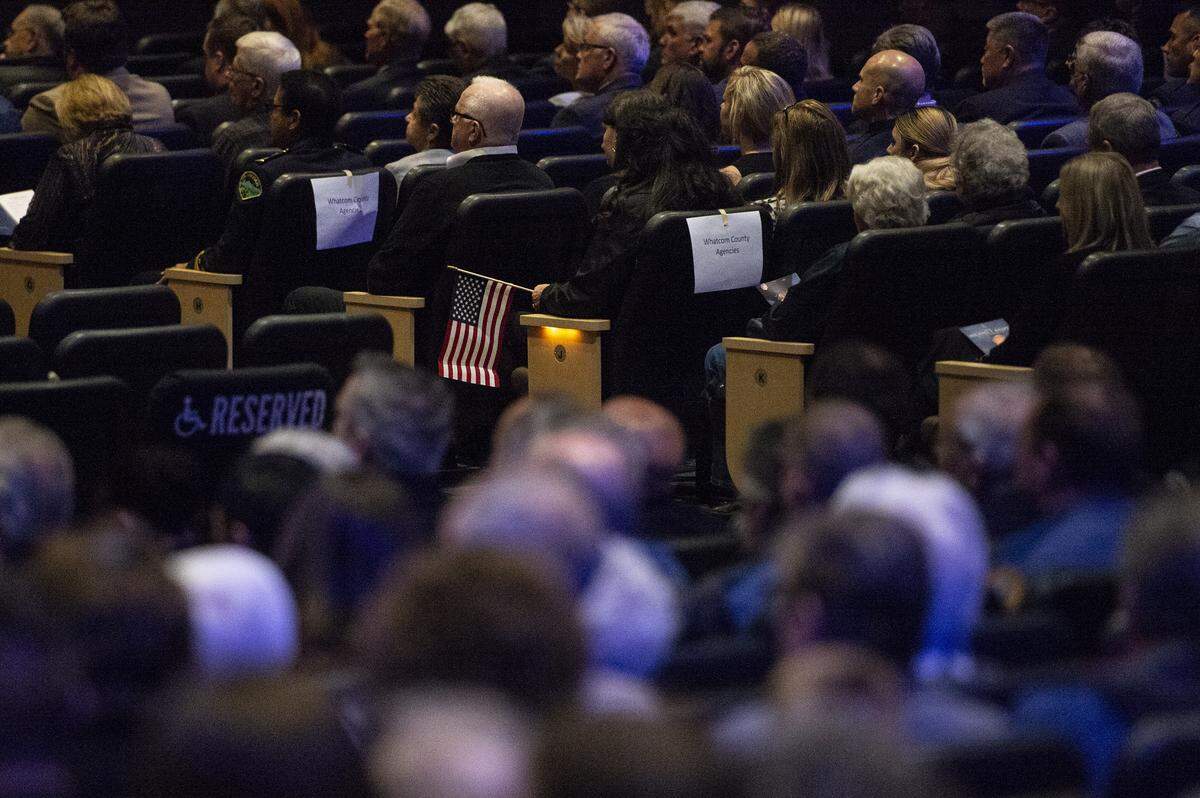 A mourner holds an American flag during Lynden interim Police Chief Michael Knapp’s memorial service at Christ the King Community Church in Bellingham Wednesday.