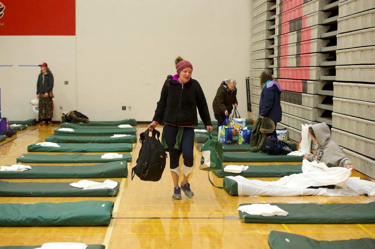 Residents of the Lighthouse Mission Ministries’ emergency Drop-In Center for the homeless move into the Bellingham High School gym Friday, March 20. The move allowed the Drop-In Center to comply with social distancing guidelines for the novel coronavirus outbreak. Now, Whatcom Unified Command is identifying a new place to relocate the Drop-In Center once it must vacate the school at the end of the summer.