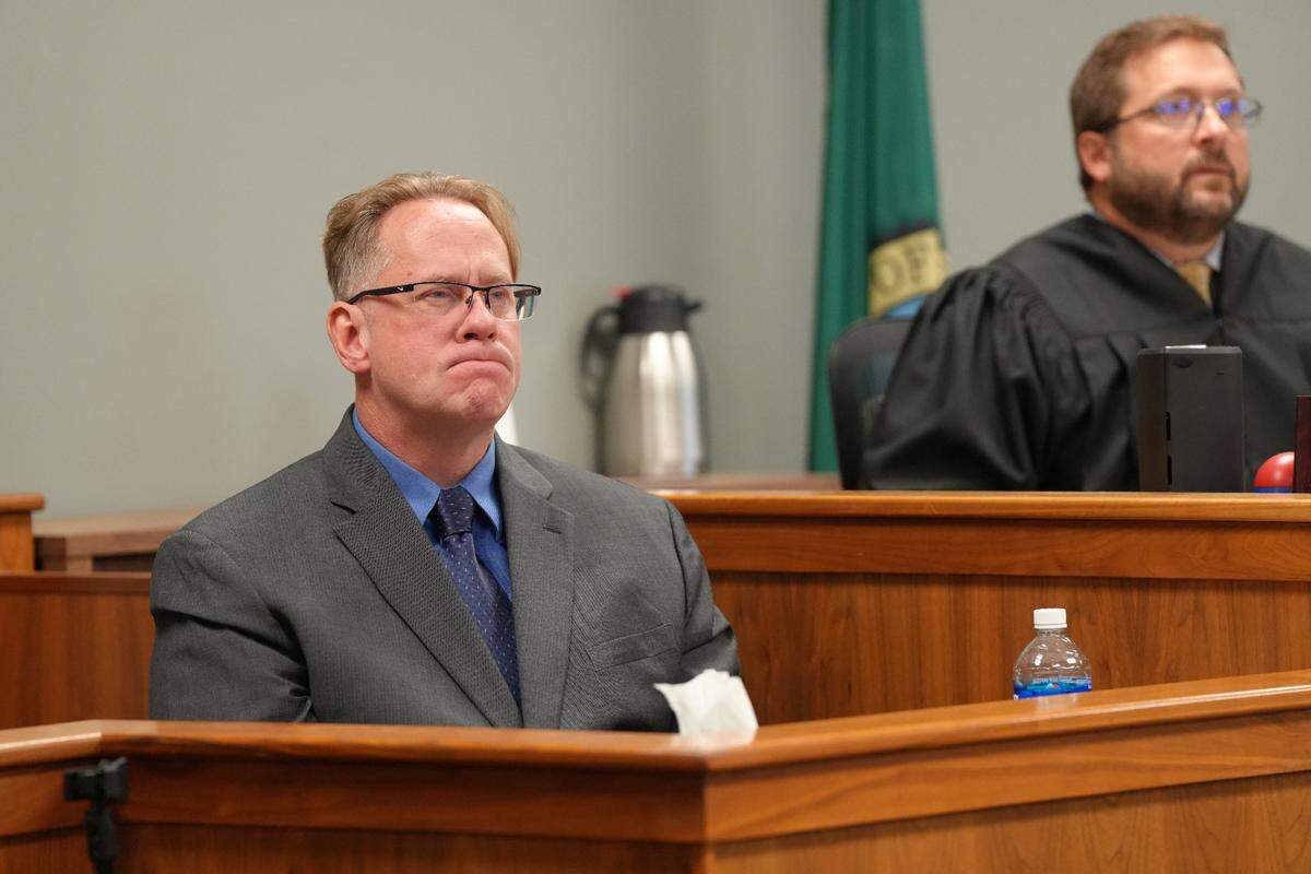 Retired Whatcom County Sheriff’s Office Deputy Jason Thompson reviews his body-worn camera footage as he testifies in court at Joel Young’s attempted first-degree murder trial on Sept. 12.