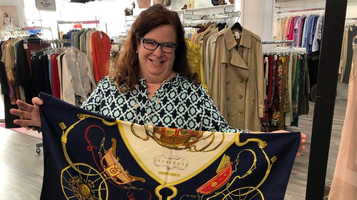 Kimberly Hoctor shows a product at Posh Upscale Resale at 1315 11th St., in Fairhaven in this June 2019 photo. The store, which consigns designer clothing and accessories, is closing but will maintain an online presence.