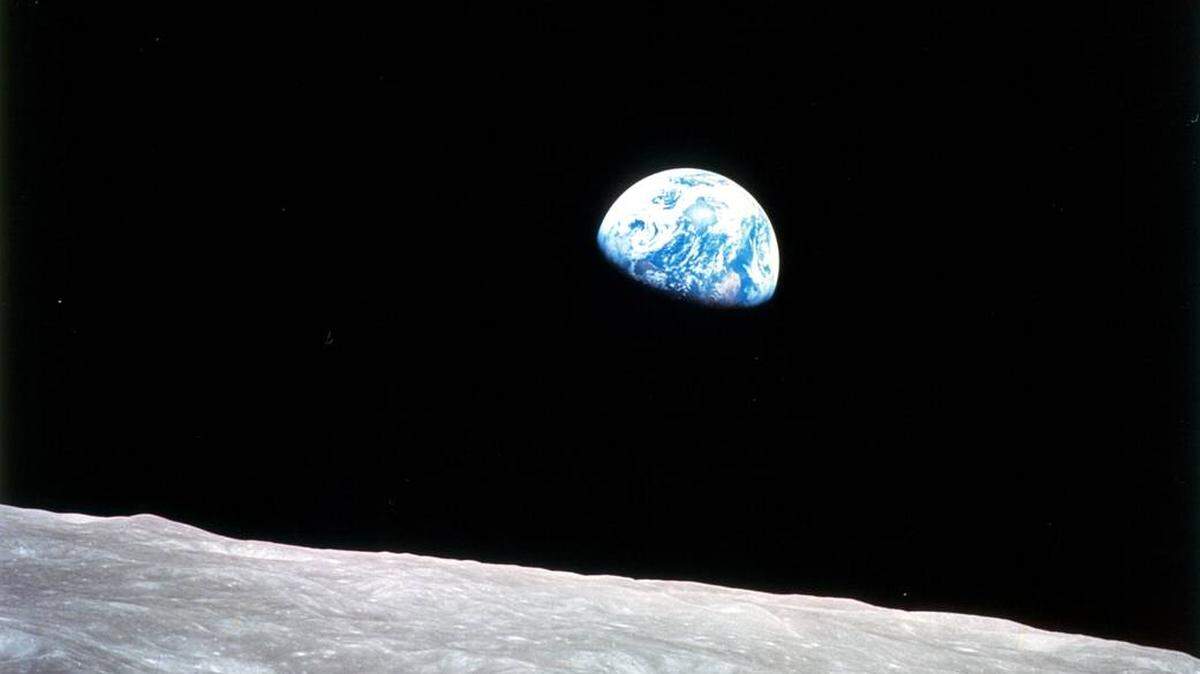 Earth rises above the lunar horizon as Apollo 8 completes an orbit of the moon on Dec. 24, 1968.