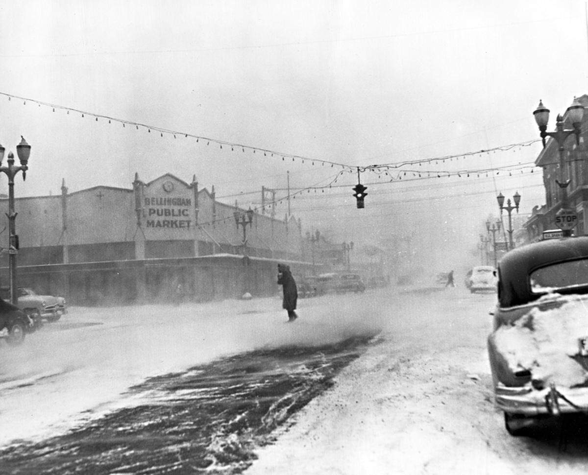 A pedestrian braves the weather at Cornwall Avenue and Magnolia Street in Bellingham in 1950 when cold-temperature records were set. There’s a Rite Aid Pharmacy on the site now.