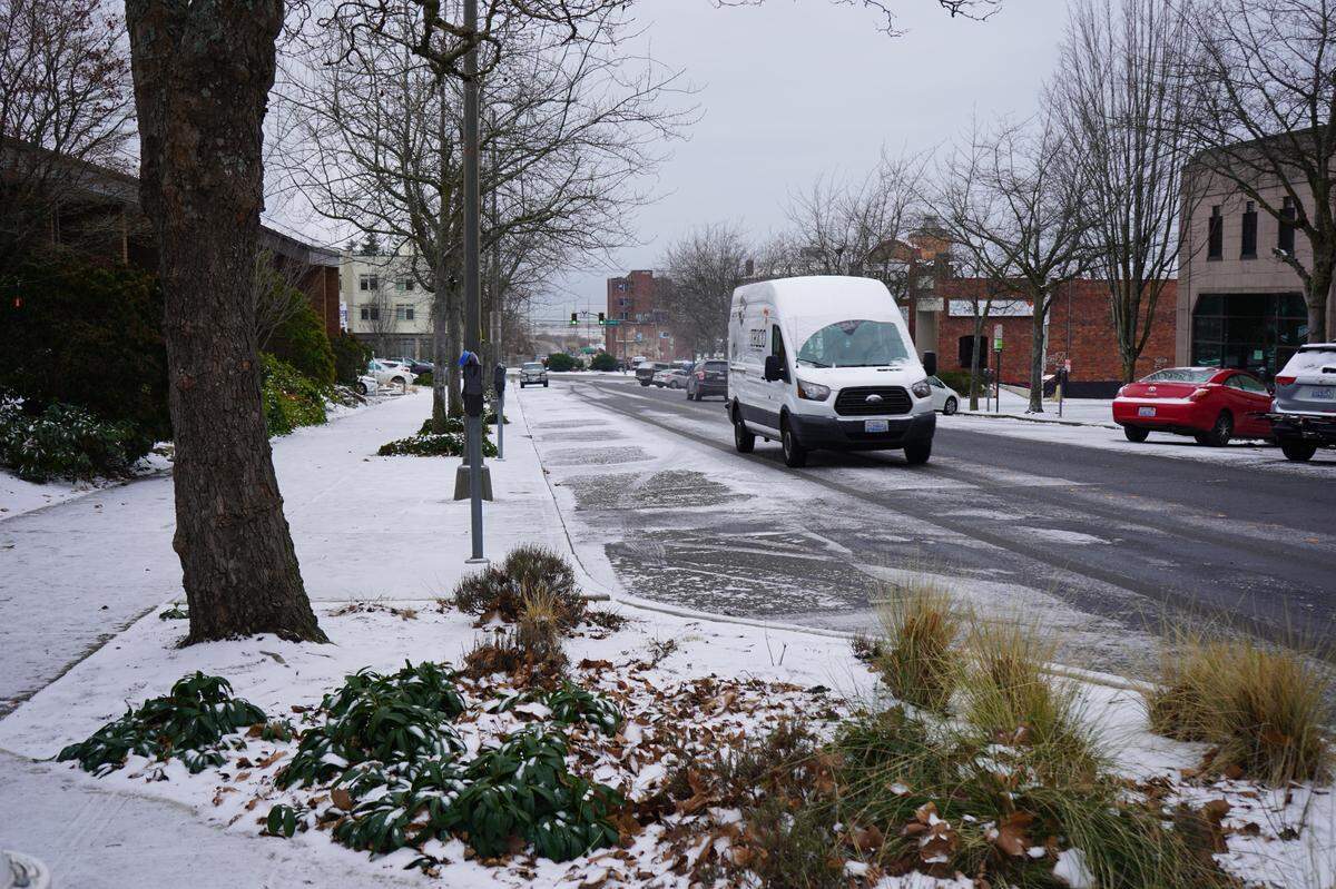 A snow-covered van drives through downtown Bellingham on Monday, Dec. 19.