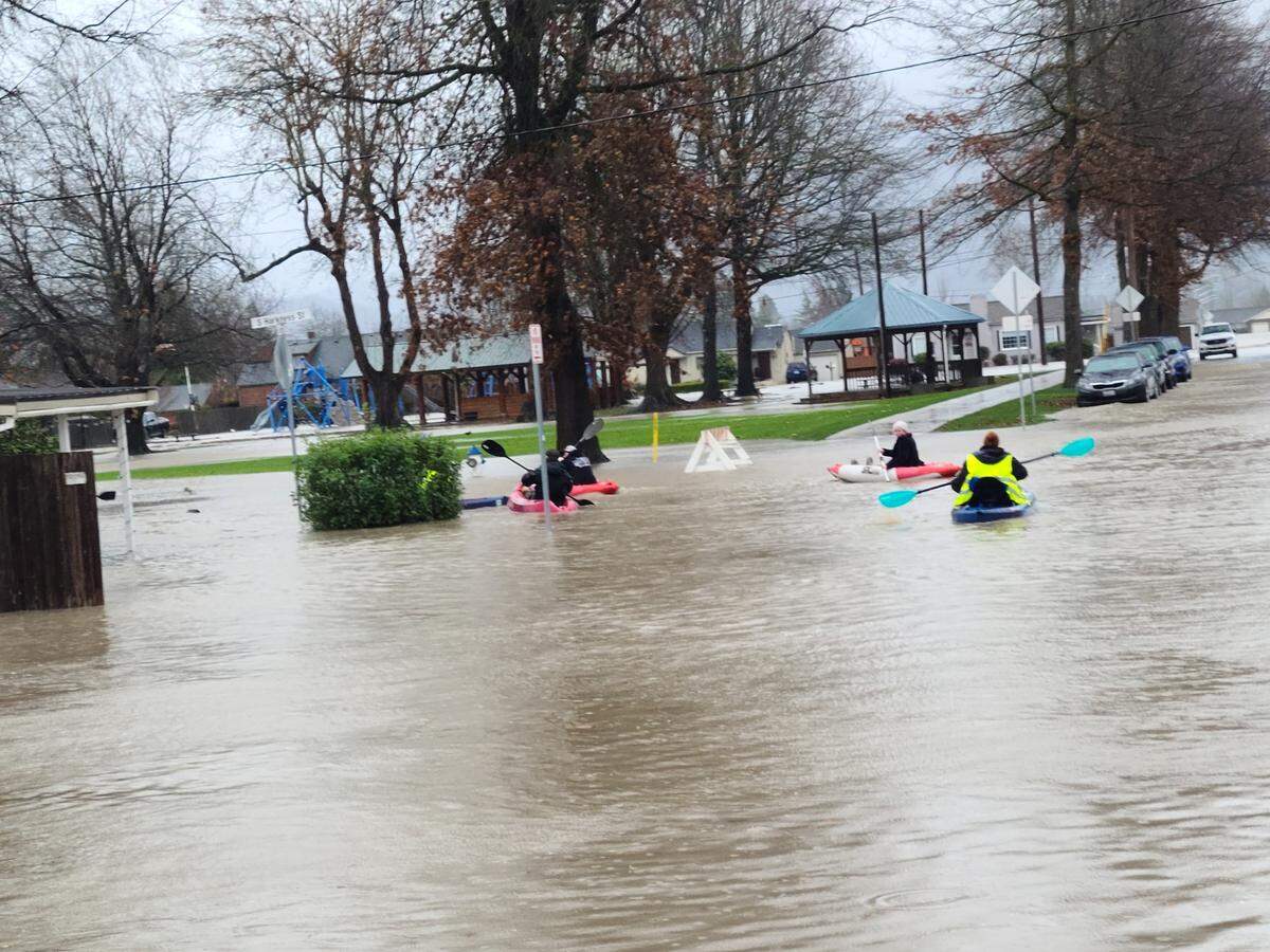 Several people kayak down the roadway in Everson after a Pineapple Express brought torrential rain and flooding to Whatcom County on Monday, Nov. 15.