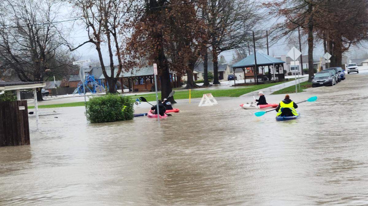 Several people kayak down the roadway in Everson after a Pineapple Express brought torrential rain and flooding to Whatcom County in 2021.