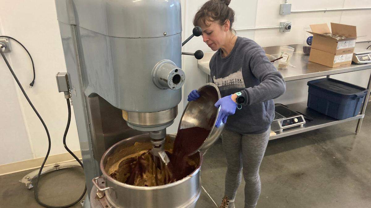 Liza Higbee-Robinson pours ingredients into a mixer. She is the co-owner of LEAP, which makes nut butter spread products in Bellingham.