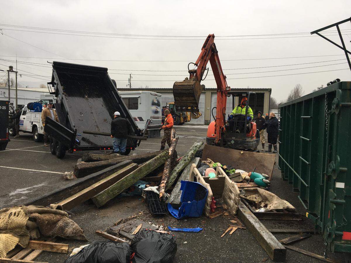 Volunteers help remove flood debris from Sumas streets and public spaces Tuesday.